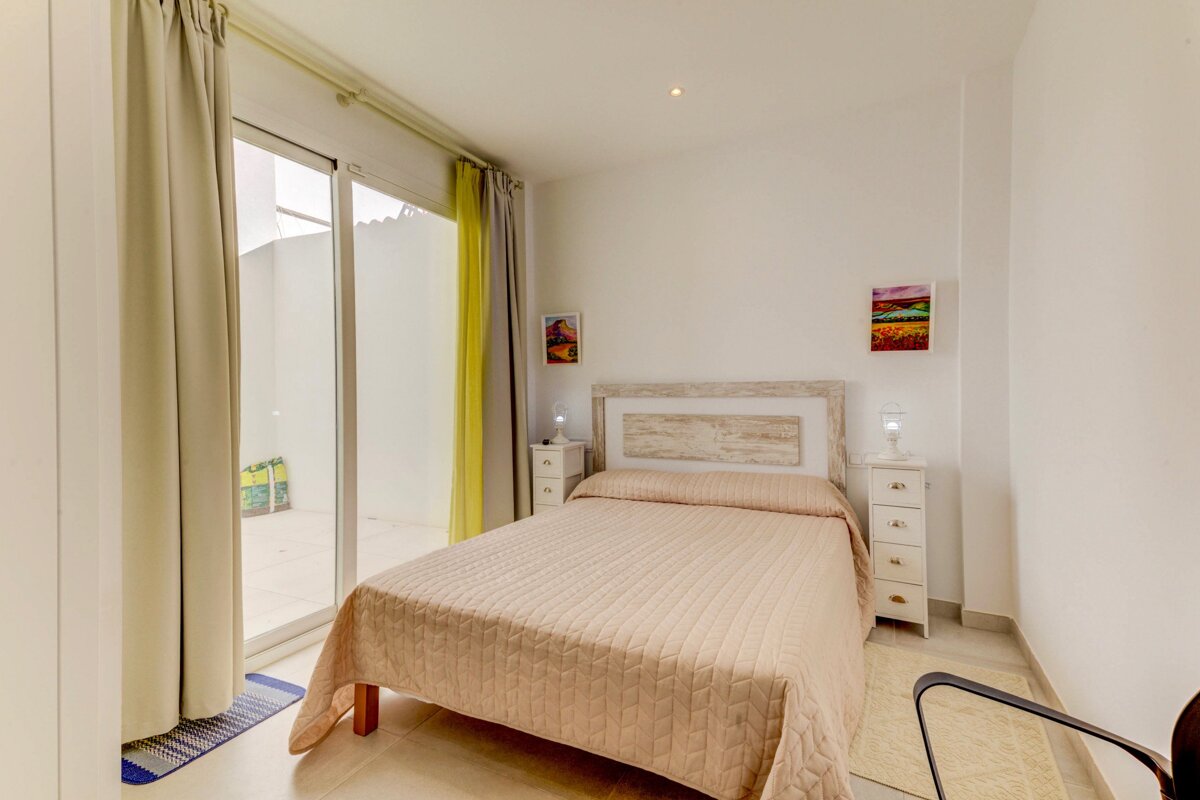A bedroom with a bed and a sliding glass door