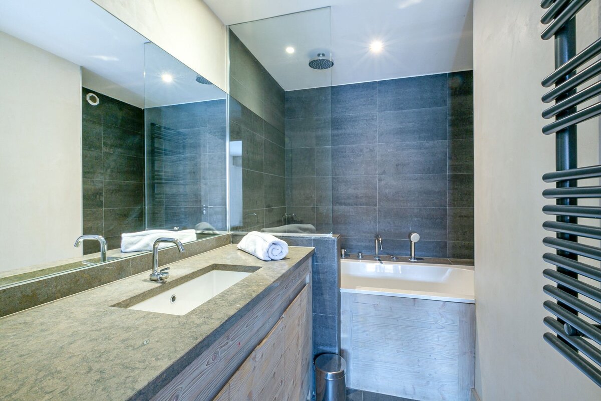 A bathroom with a sink and a walk in shower