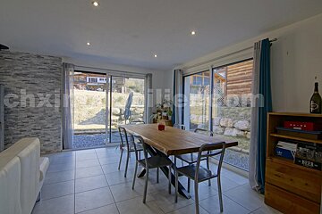 A dining room with a table and chairs and the word chx on the wall