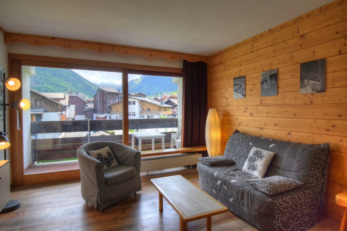 A living room with a yellow couch and a flat screen tv