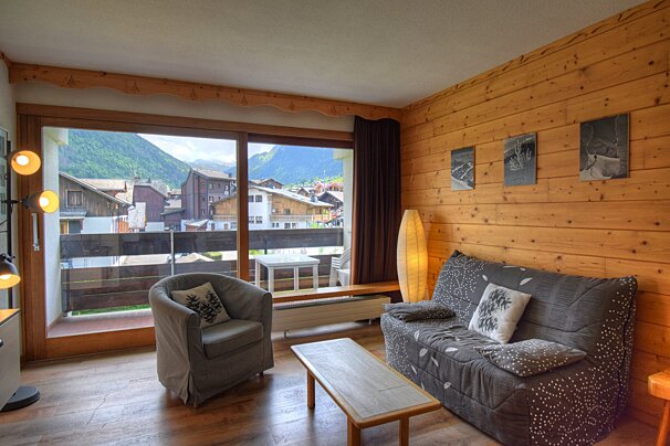 A living room with a yellow couch and a flat screen tv
