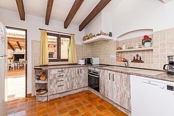 A kitchen with wooden cabinets and a white dishwasher