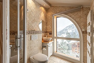A bathroom with a large window and a toilet