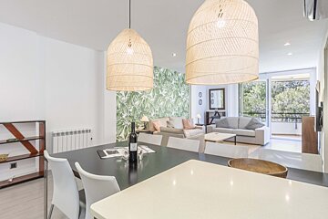 A dining room table with a bottle of wine on it