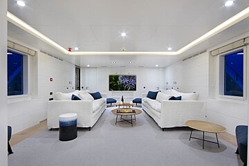 A living room with white furniture and a painting on the wall