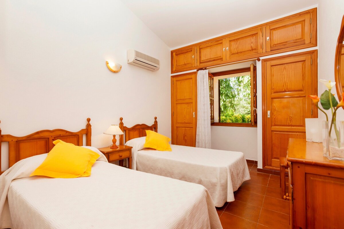 A bedroom with two twin beds and a window