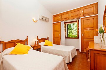 A bedroom with two twin beds and a window