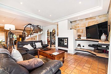 A living room with a fireplace and a staircase