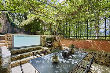 A patio with a table and chairs and a sign that says provence by immobilier