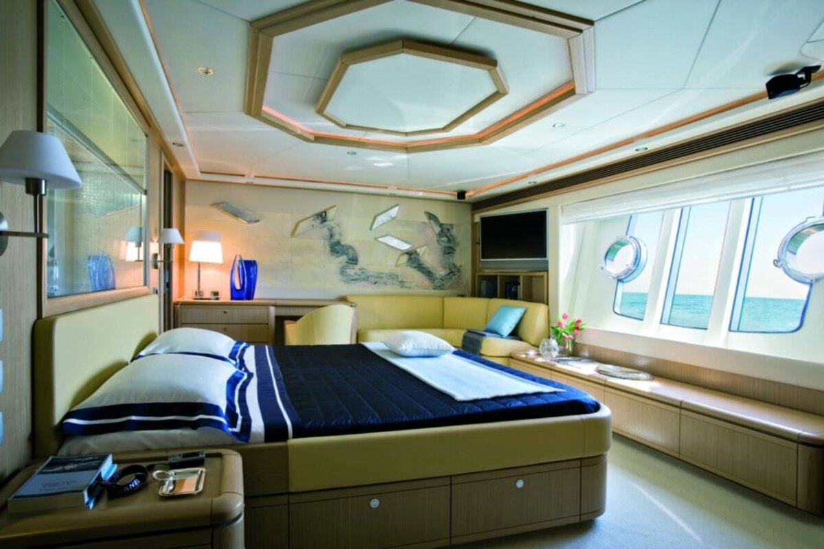 A bedroom with a large bed and a painting on the wall
