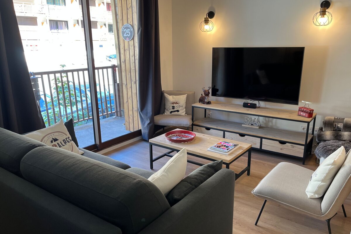 A living room with a couch a chair and a flat screen tv