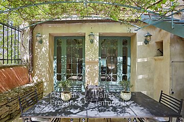 A patio with a table and chairs and a sign that says manssens provence immobilier