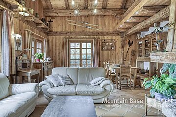 A living room with a couch and chairs and a sign that says mountain base immobilier real estate