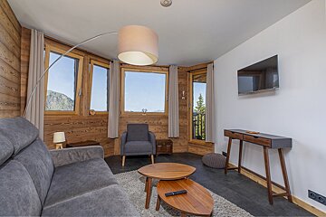 A living room with a couch a chair and a flat screen tv