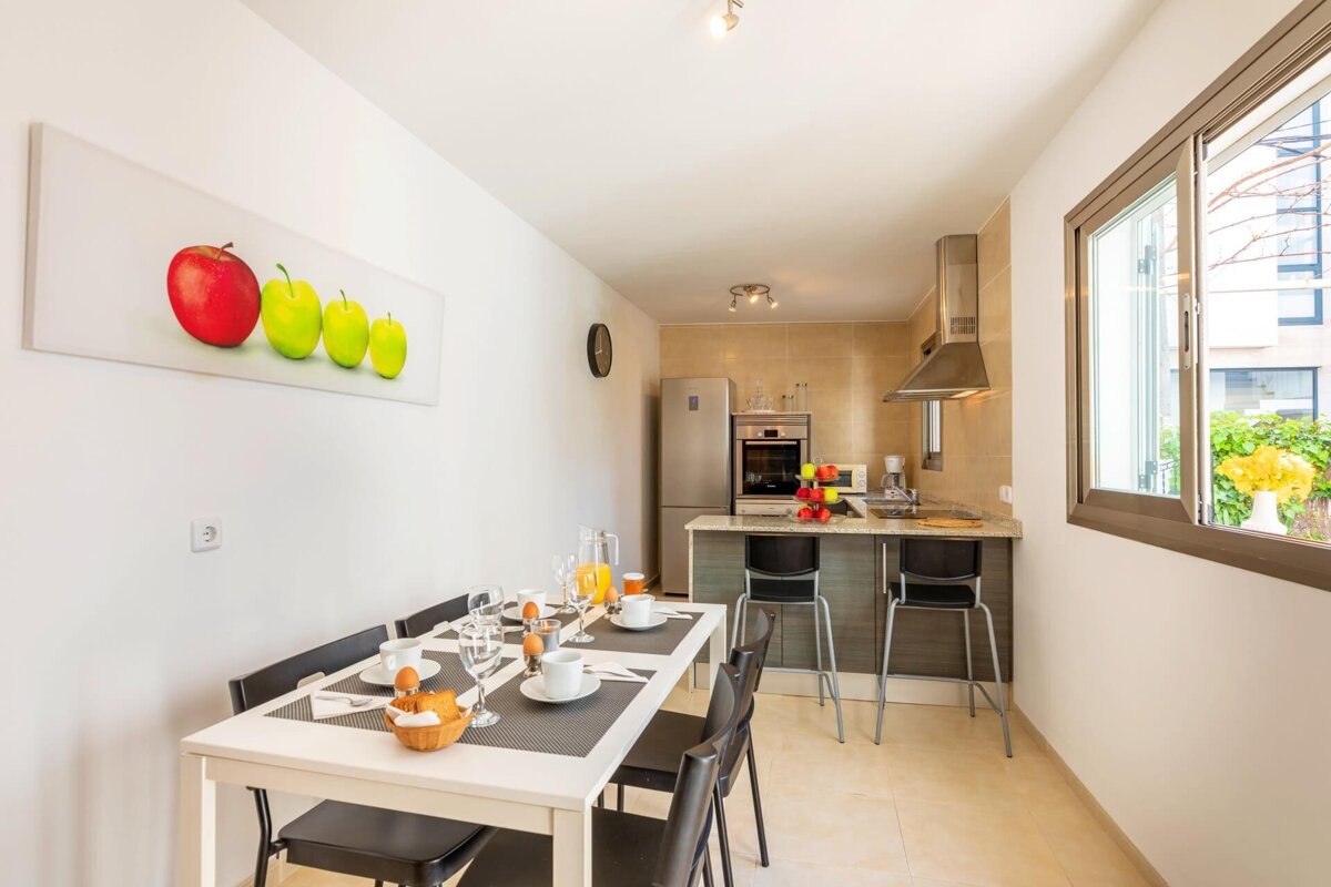 A kitchen with a table and chairs and a picture of apples on the wall