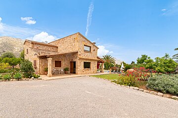 A large stone house with a driveway leading to it