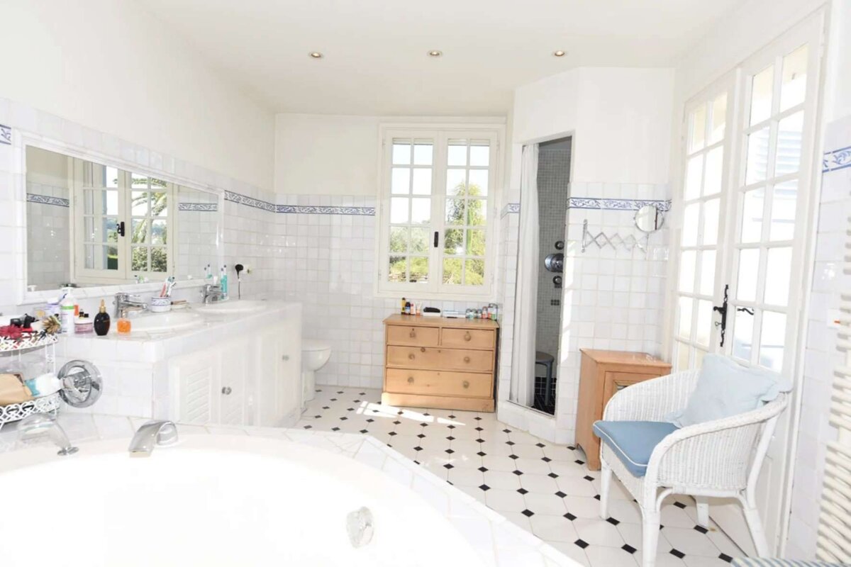 A bathroom with two sinks and a chair