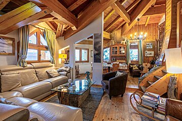A living room with a couch and chairs and a glass coffee table