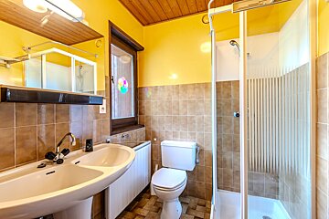 A bathroom with a toilet a sink and a shower
