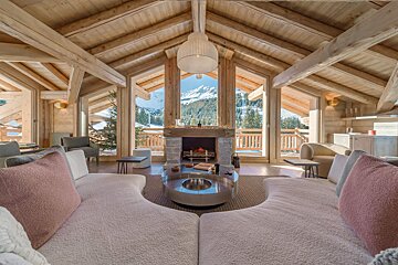 A living room with a fireplace and a view of the mountains