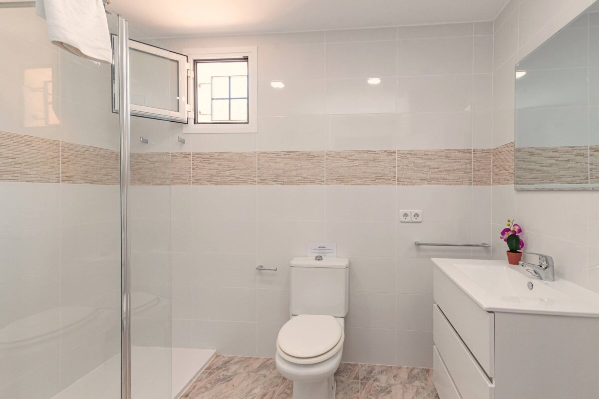 A bathroom with a toilet a sink and a window