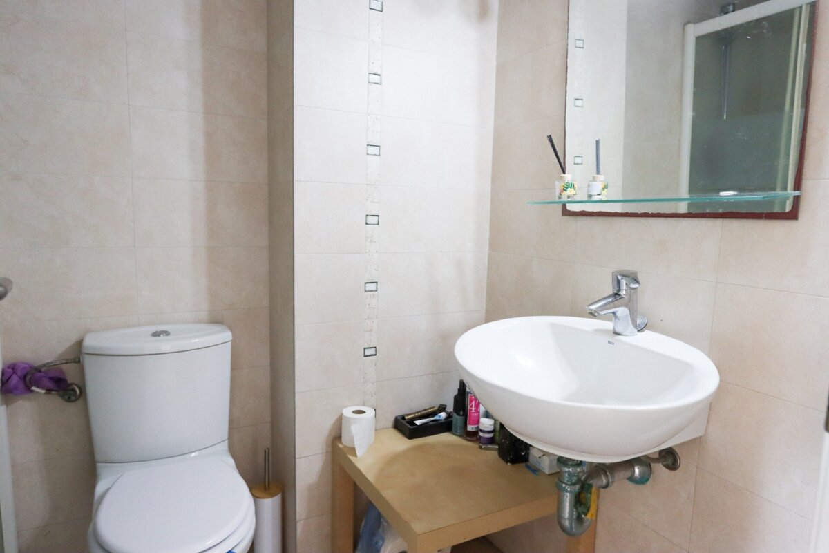 A bathroom with a toilet a sink and a mirror