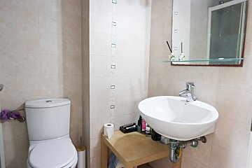 A bathroom with a toilet a sink and a mirror