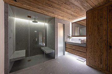 A bathroom with a walk in shower and a sink