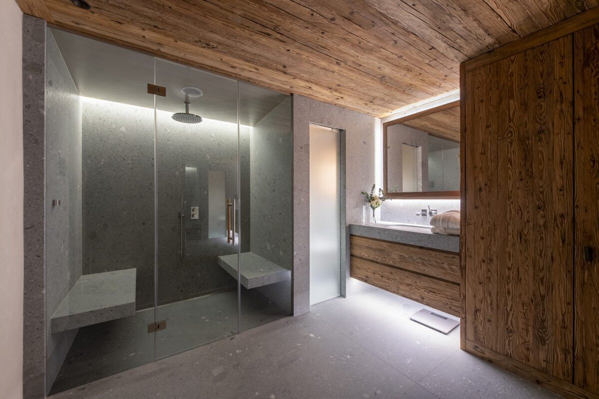 A bathroom with a walk in shower and a sink