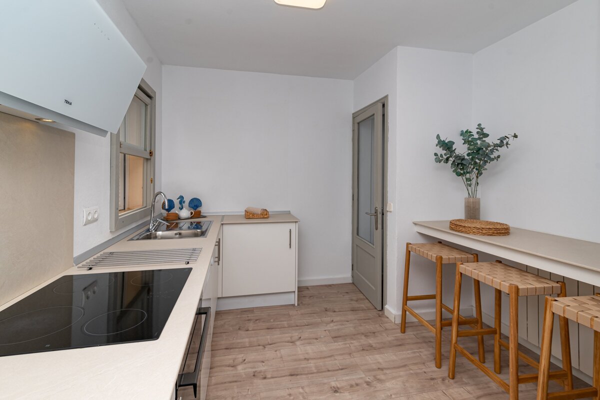 A kitchen with a stove top oven and a sink