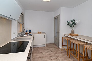 A kitchen with a stove top oven and a sink