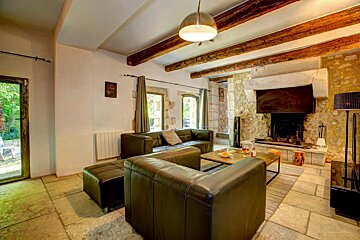 A living room with two leather couches and a fireplace