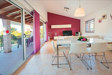 A living room with a table and chairs and a television