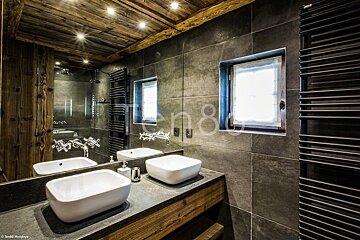 A bathroom with two sinks and a mirror with the number 8 on it