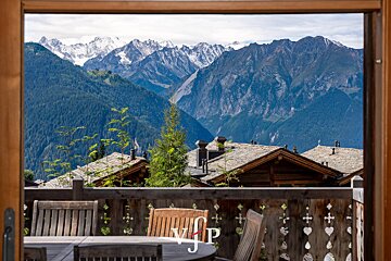 A view of a mountain range from a balcony with a vjp logo