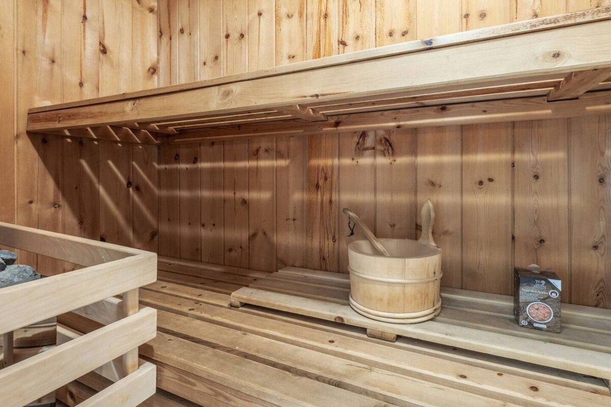 A wooden bucket sits on a shelf in a wooden sauna
