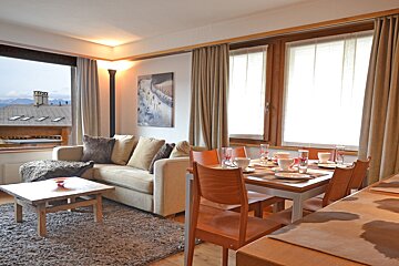 A living room with a couch and a table and chairs