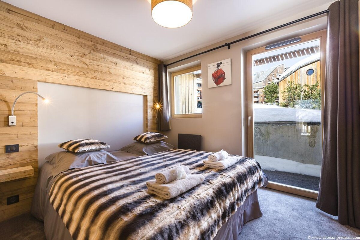 A bedroom with a painting on the wall above the bed