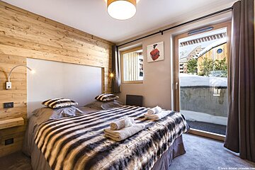A bedroom with a painting on the wall above the bed