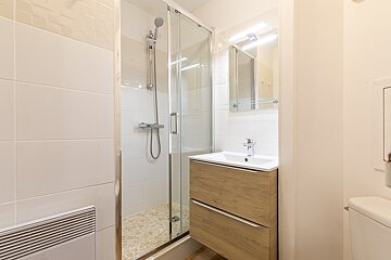 A bathroom with a sink and a walk in shower