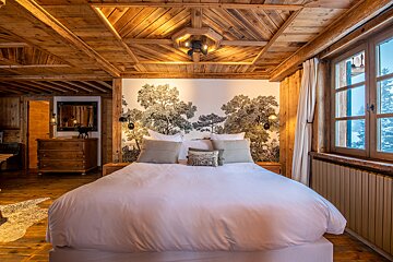 A bedroom with a large bed and a dresser