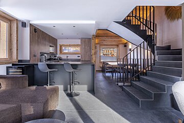A kitchen with a staircase leading up to the second floor