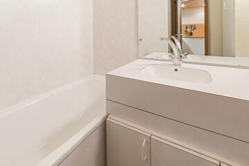A bathroom with a sink and a bathtub and a mirror
