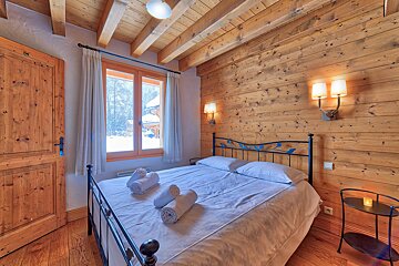A wooden bedroom with a bed and a window
