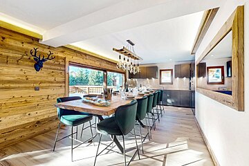A dining room with a long wooden table and chairs