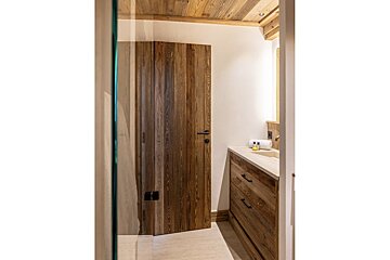 A bathroom with a wooden door and a sink