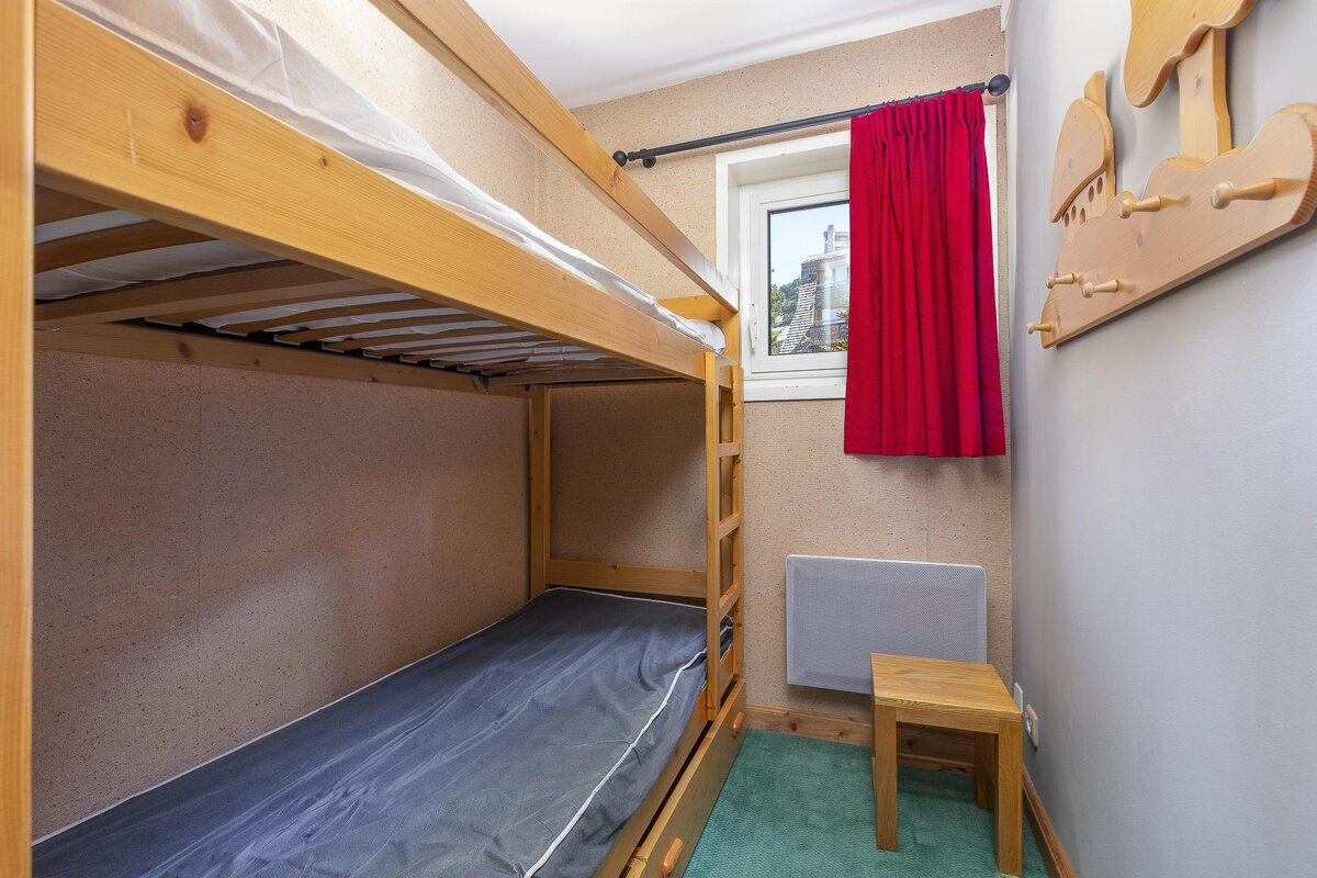 A bedroom with bunk beds and a red curtain