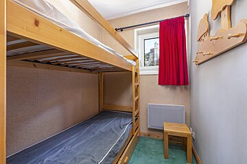 A bedroom with bunk beds and a red curtain