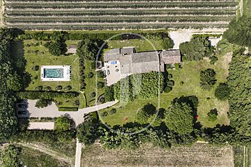An aerial view of a house with a large pool