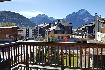 A balcony overlooking a city with mountains in the background
